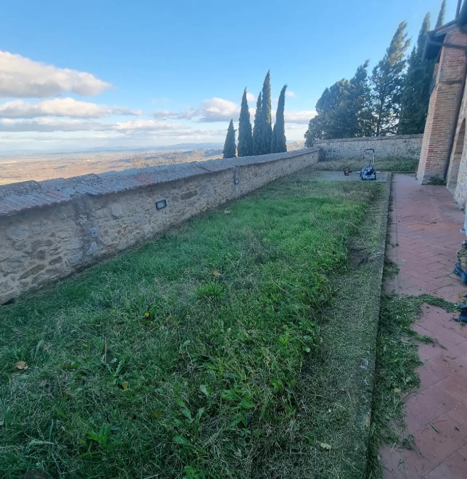 Prato appena tagliato lungo un muretto in pietra